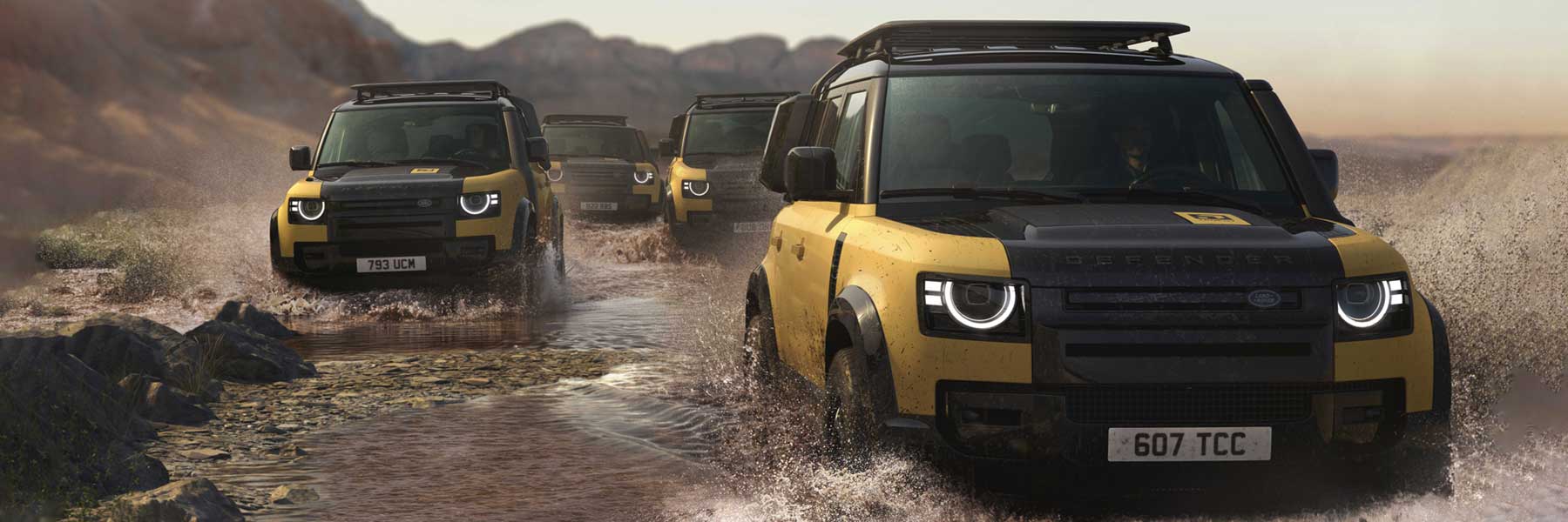 Defender Trophy - Category Banner Quattro Defender nella livrea Trophy (moderno giallo sabbia e nero) risalgono un fiume, mostrando straordinarie capacità fuoristrada.